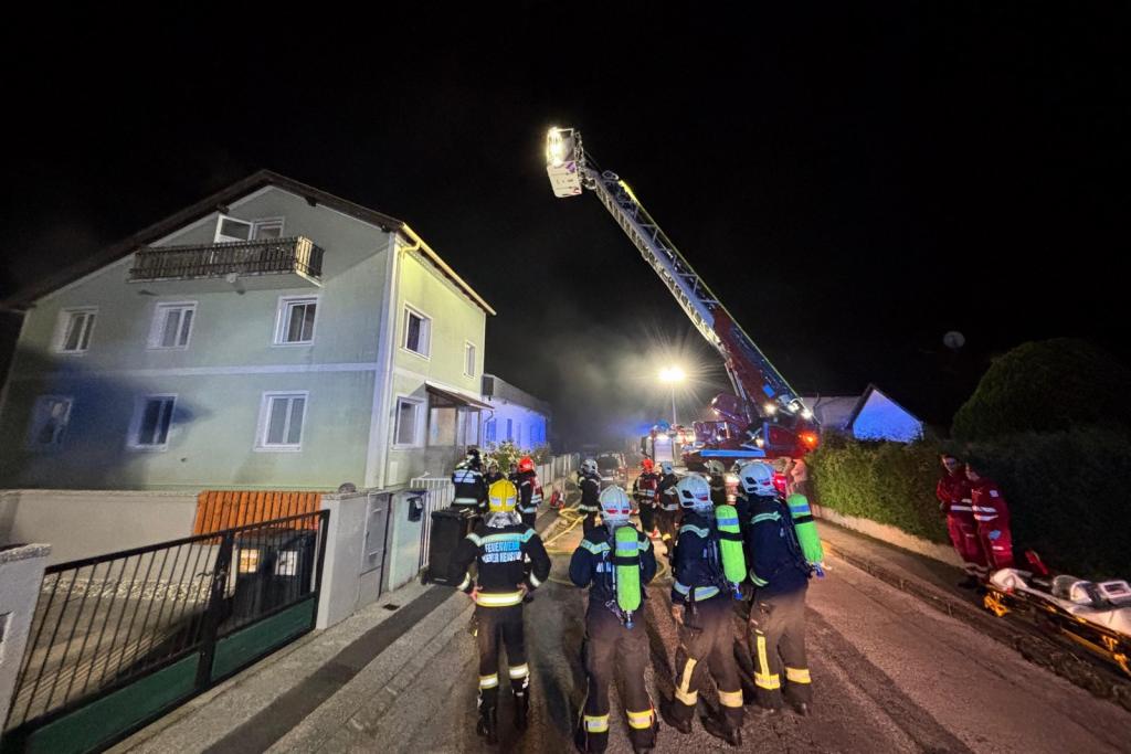 FF Wr. Neustadt: Kellerbrandeinsatz - Mannschaft und Hubrettungsgerät vor Haus auf Straße