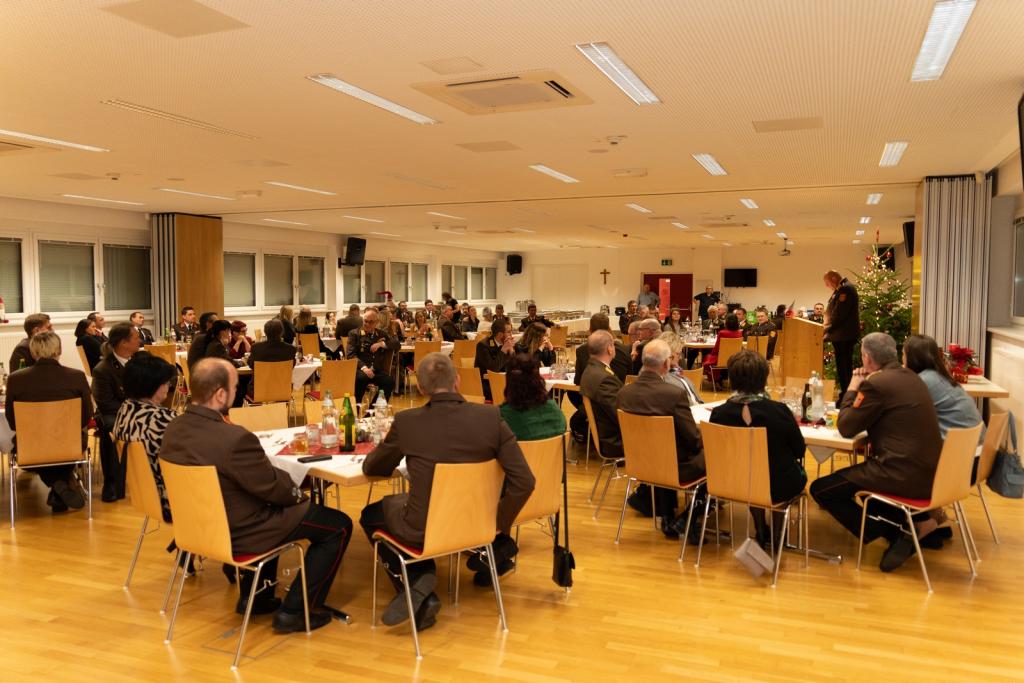 Bezirkskommandositzung in Wiener Neustadt - Otto-Sommer Sall mit Tischen  mit sitzenden Feuerwehrmitgliedern und BFKDOT Greiner am Rednerpult