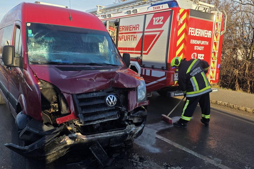 Verunfallter Kleintransporter und Feuerwehrfahrzeug mit kehrenden Feuerwehrmann