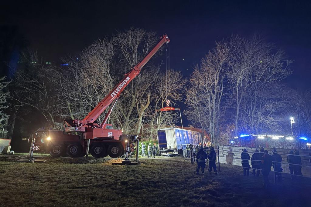 LKW Bergung Ebenfurth - Feuerwehrkran hebt LKW an mit Feuerwerhmitliedern vor Bäumen
